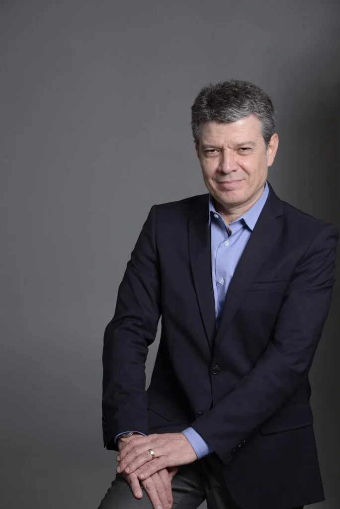 retrato profissional de homem de meia idade, de camisa e terno sem gravata, em ambiente de fundo cinza