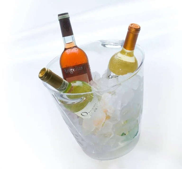 balde transparente com gelo e três garrafas de bebidas