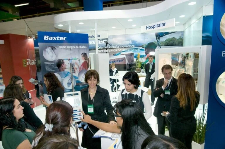 stand de feira hospitalar, da empresa de saúde Baxter, funcionários com crachá atendendo interessados no local
