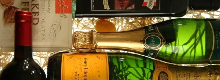 garrafas de champanhe com caixa de bombons, posicionadas lateralmente