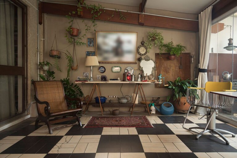 Área externa de apoio em estúdio fotográfico decorada com plantas e mesa com café